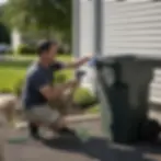 Homeowner rinsing a lightly dirty trash can with a garden hose in Elkton