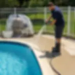 Worker rinsing pool deck with hose angled away from open pool water