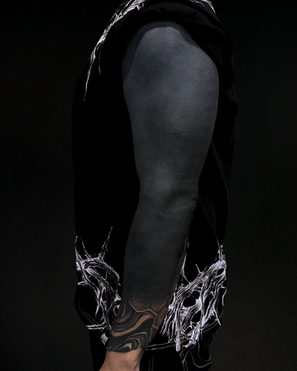 Full blackout leg sleeve tattoo with ornamental blackwork near the wrist.