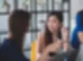 Das Bild zeigt zwei Frauen in einem Gespräch, die an einem Tisch sitzen. Eine der Frauen blickt aufmerksam zur anderen, während diese gestikuliert. Bild von Mimi Thian