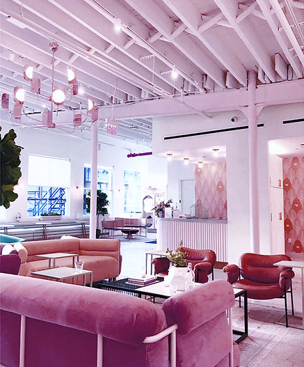 This is a photo of a lounge with pink comfortable chairs and tables for dining