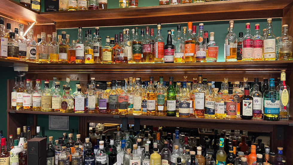 Eye-level view of a selection of whisky bottles on a wooden shelf