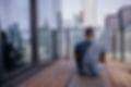 person-sits-on-a-grey-yoga-mat-on-a-wooden-deck.jpg