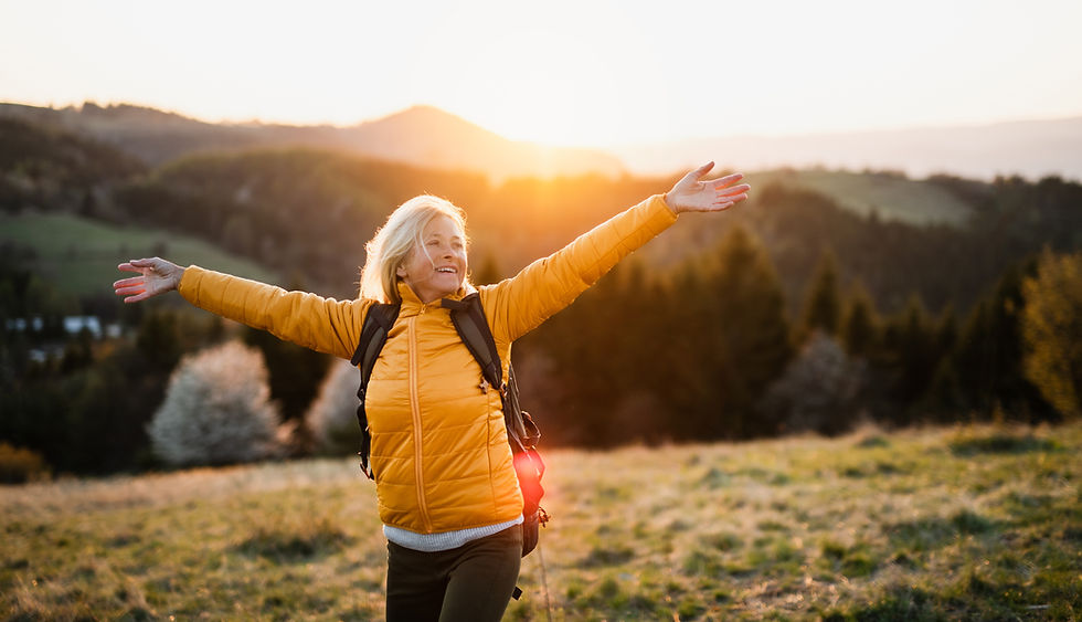 Front view of senior woman hiker standing outdoors in nature at sunset..jpg