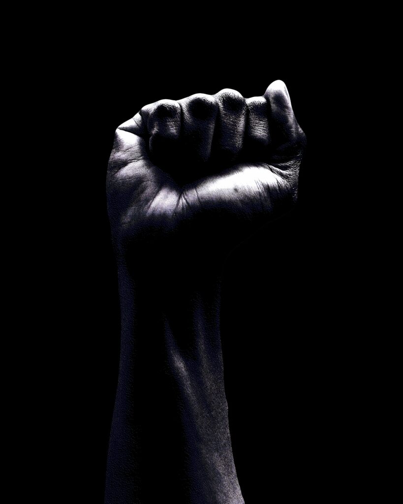 Fist held up against black background