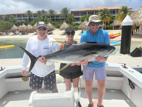 Guests with a 110 lb yellowfin tuna caught offshore in Curaçao