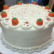 Carrot Cake Decorated with Pumpkins, Swirls, and Sprinkles.