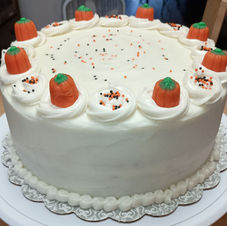 Cake with White Frosting and Orange Pumpkins on Swirls.