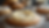 Close-up of freshly baked pastry with cream and powdered sugar. Background shows more pastries on a cooling rack. Warm, inviting atmosphere.