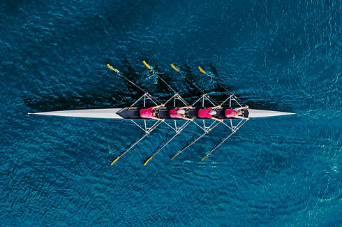 Bird's eye view of a rowing team on a calm lake