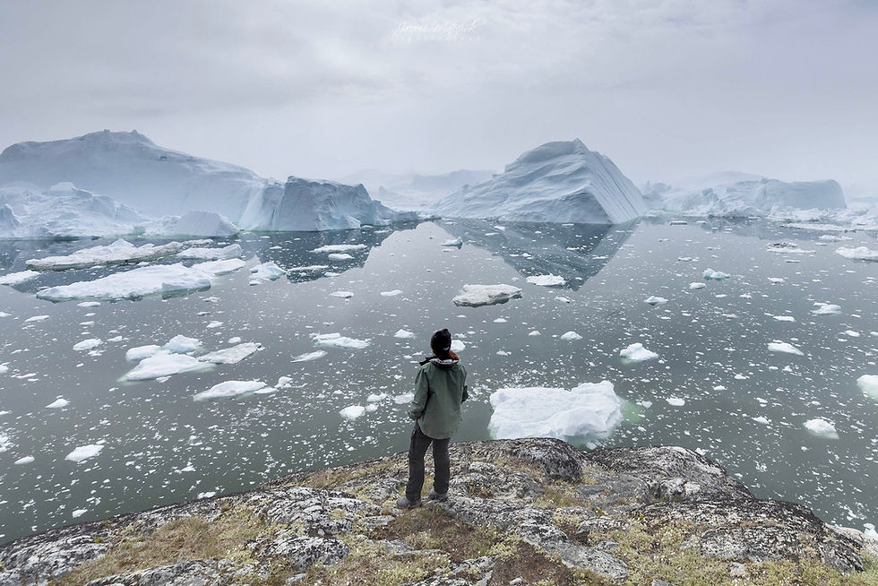 Standing on the rocky edge of Ilulissat, Greenland overlooking miles of fractured ice