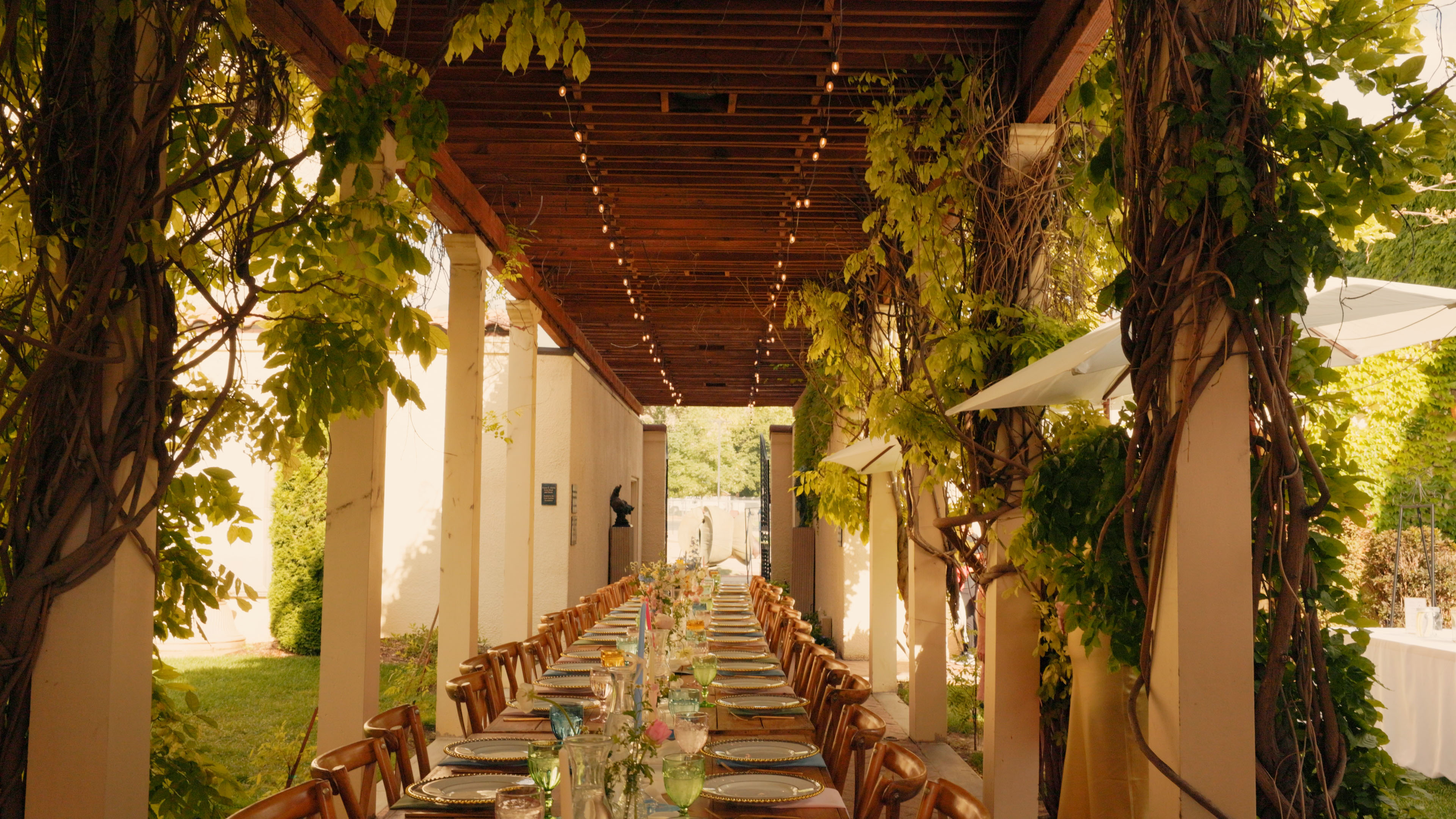 An outdoor wedding reception with carefully arranged tables and greenery