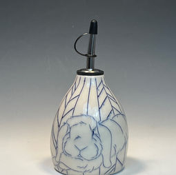 A pear-shaped white lamp base, decorated with blue lines depicting a fluffy bunny against a background of geometric angles.