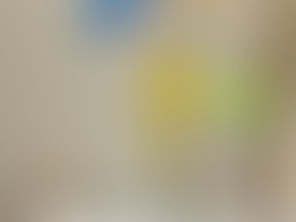 A metal-stemmed sculpture of several flowers and a butterfly in bright, translucent colors.