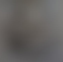 A round, geometrically textured metallic wood sculpture.