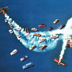 A semi-realistic depiction of old cars and planes crashing into and driving/flying over dark blue water.