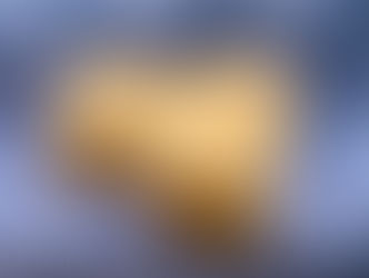 A uniquely shaped wooden box with intricate leaf carvings on the lid, against a blue backdrop.