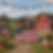 Two Highland cow figurines in patriotic hats holding American flag with red barn and patriotic bunting in farm setting