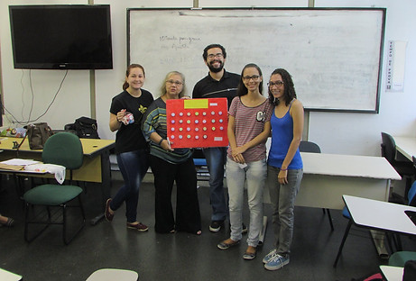 Turma de alunos com a profa. Edicléa demonstrando um quadro com adaptações.