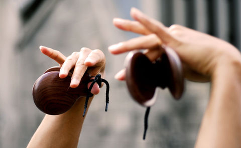 Hands in the air holding castanets