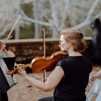 String trio violinist performing at outdoor wedding ceremony with sheet music stand, elegant live music at Historic Graylyn Estate in Winston-Salem, North Carolina