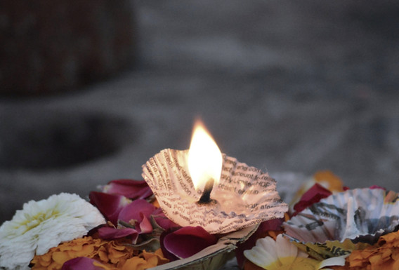 Brennende Kerze mit Blüten als stilles Ritual des Abschieds