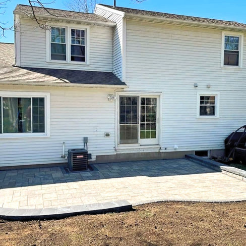 backyard paver stone patio with retaining wall
