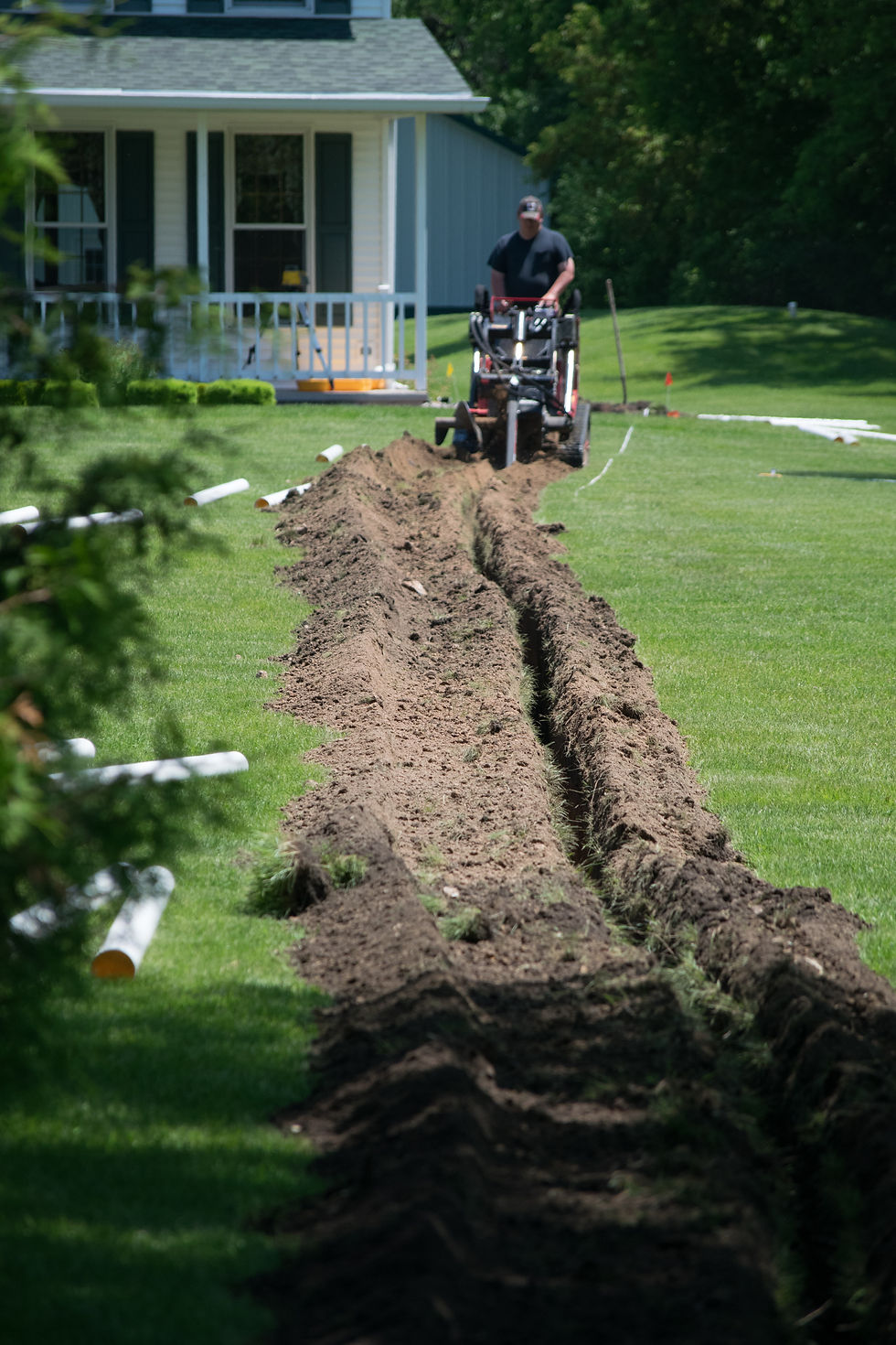 Trench Dug in the Green Yard by a Trench Digger for PVC Water Drainage Pipe