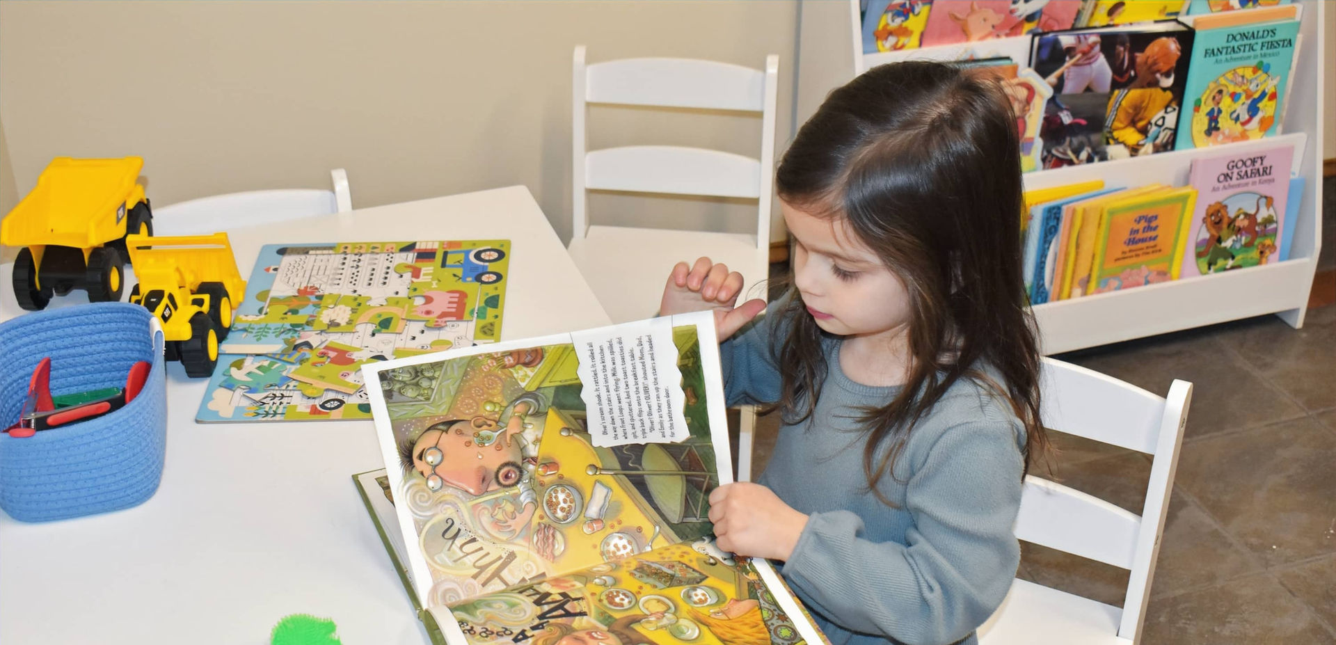 girl reading in pediatric waiting room at Syracuse Dental Specialists