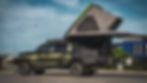 Full side view of the Nori Green chopped 200 Series with rooftop tent and awning fully open, lit by soft natural lighting.