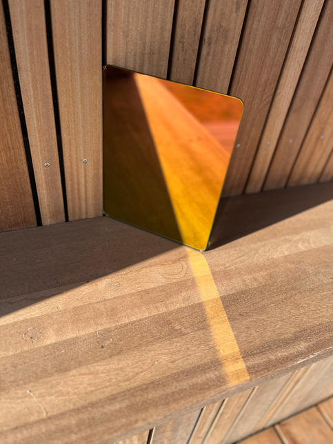 FÚ dawn rainbow color mirror. 
Fu Spiegel
Spiegel mit Farbverlauf wie ein Regenbogen. yellow to magenta, color gradient on wooden table