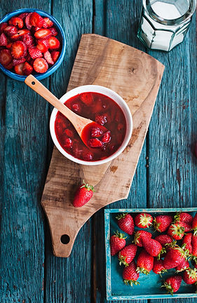 Rustic atmosphere with homemade strawberry confiture with same fruits over on blue vintage