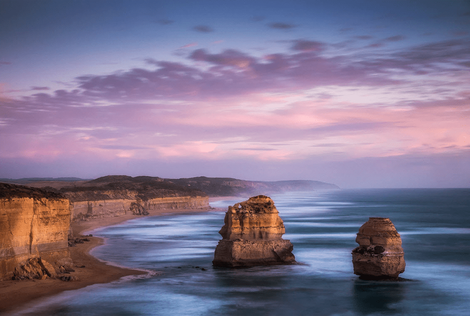 sunset over the sea with cliff beaches and rock islands