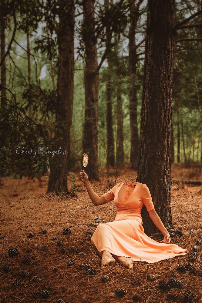 headless woman in an antique dress looking into a mirror