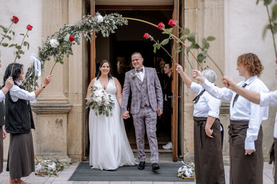 Brautpaar beim Auszug aus der Kirche in Bad Krozingen, empfangen von Hochzeitsgästen mit Blumen