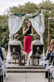 Traurednerin spricht bei einer freien Trauung im Dialekt in Merdingen unter einem Traubogen