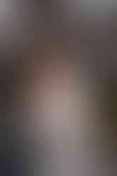 Brautpaar beim Brautpaarshooting, welches im Gang eines alten Gewächshauses steht und der Bräutigam die Braut von hinten umarmt und an der Stirn küsst