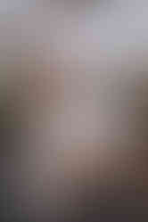 das Brautpaar hinter dem Tisch mit dem Champagnerturm darauf, er küsst die Braut auf die linke Wange