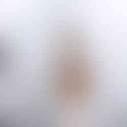 Braut mit Blumenstrauß posiert elegant vor der Glaspyramide des Louvre in Paris