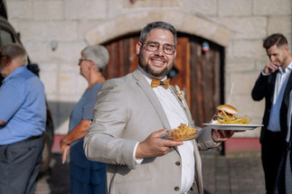Der Bräutigam, der seinen Burger am Foddtruck geholt hat und sich sichtlich darüber freut