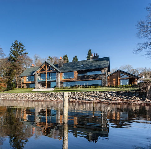 Modern stone, wood, and glass lakefront home – luxury residential construction UK