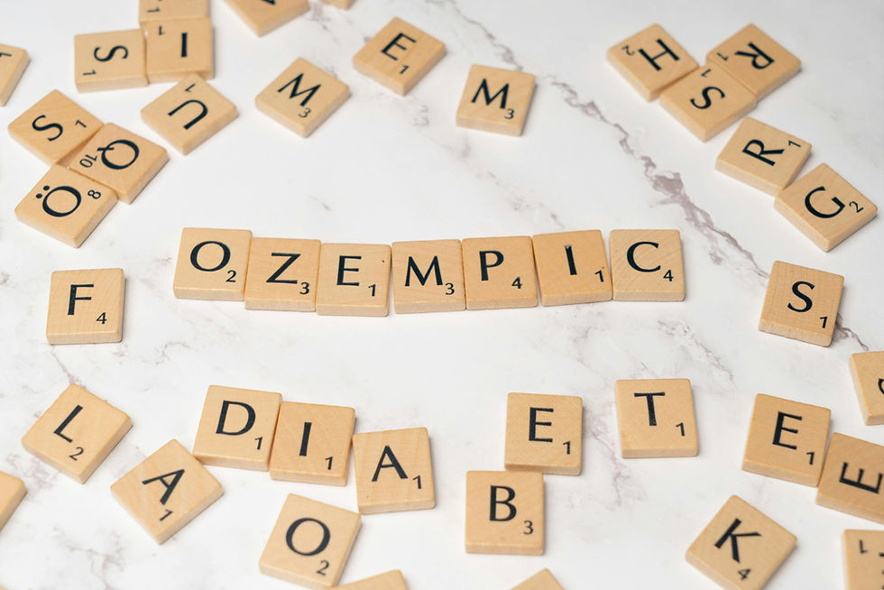 Puzzle letters spelling "Ozempic" on a marble background, with other scattered tiles suggesting themes of health and medication.