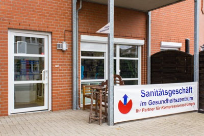 Außenansicht des Geschäftes mit Klinkersteinen und großzügiger Terrasse.