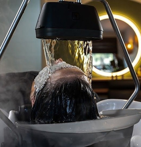 Guest receiving a YUME head spa treatment with water flowing over the scalp