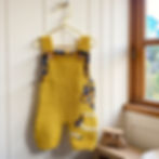 Handknitted yellow merino wool baby dungarees with tartan kite motif and tartan trim on bib and back
