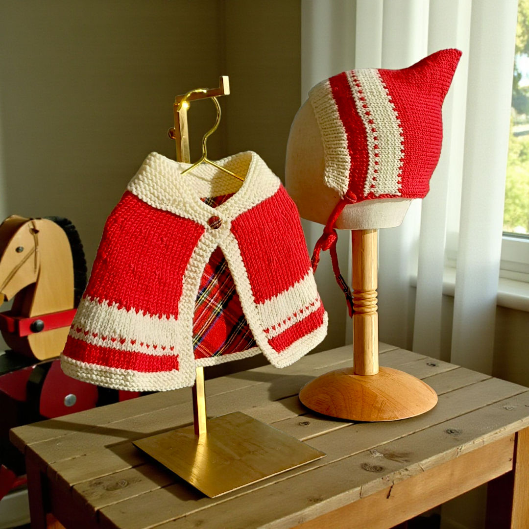Handknitted merino wool baby capelet and pixie hat in red and cream with tartan trim