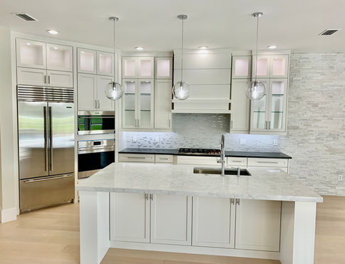 Before and after comparison of a dark traditional kitchen remodel into a bright modern white kitchen in Sarasota