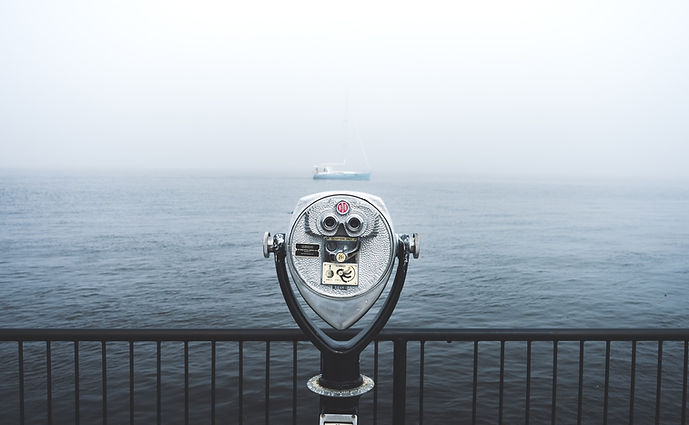 Coin-operated binoculars on a pier, pointing at a ship in the distance.