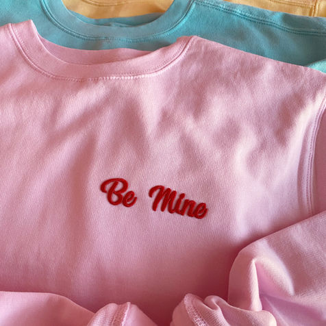 pink embroidered be mine crewneck sweater with red thread