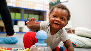 Smiling baby crawling and reaching out